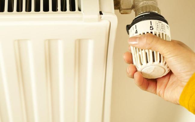 Una persona ajusta la temperatura de su calefacción