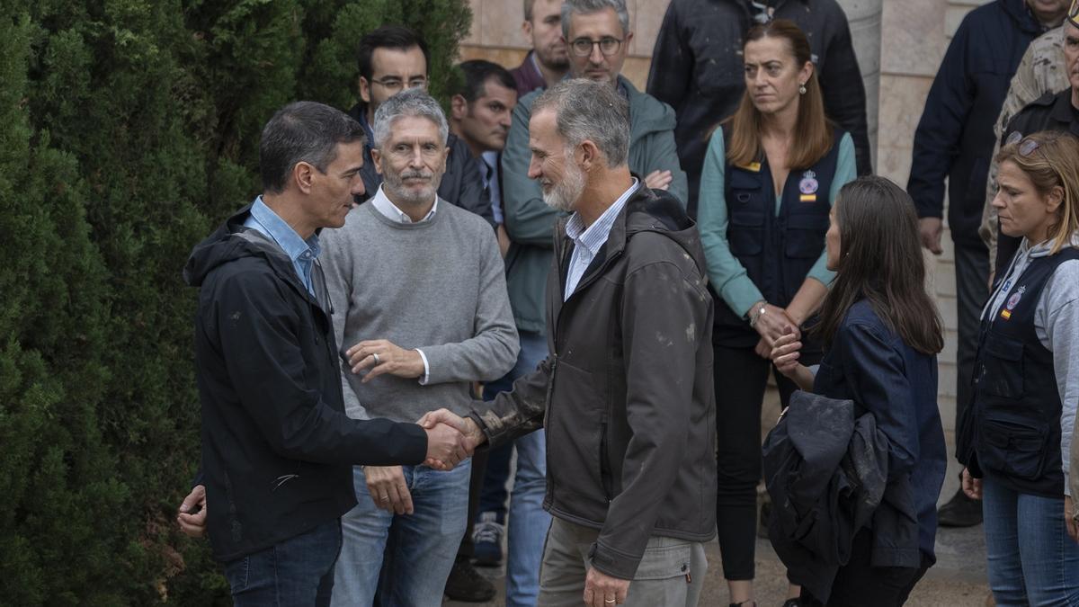 Felipe VI saluda al presidente del Gobierno español, Pedro Sánchez, durante su visita al centro del 112, en Valencia.