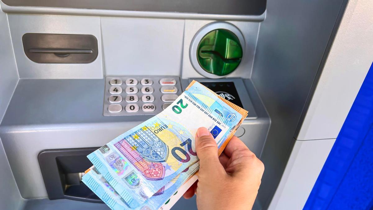Una persona retira dinero de un cajero automático.
