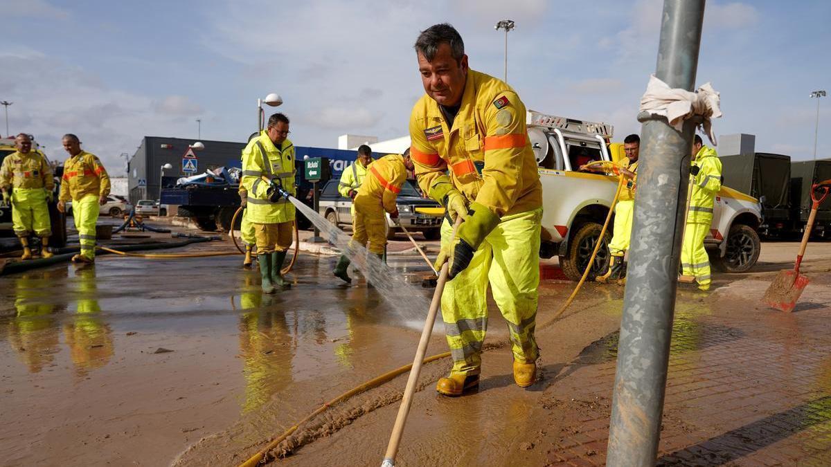 Varias personas realizan trabajos de mantenimiento durante la dana de Valencia.