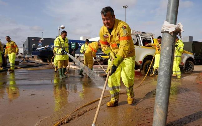 Varias personas realizan trabajos de mantenimiento durante la dana de Valencia.