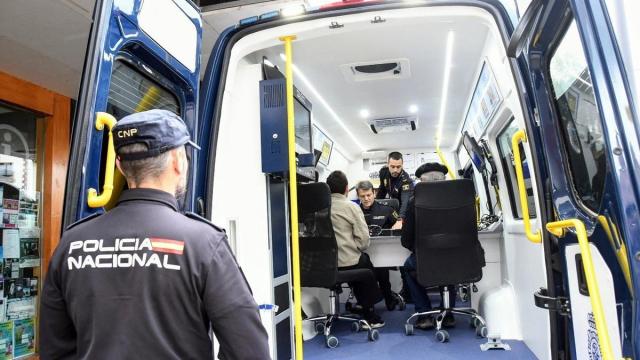 Funcionarios policiales atendiendo a unos ciudadanos en la furgoneta de expedición y renovación de documentos.