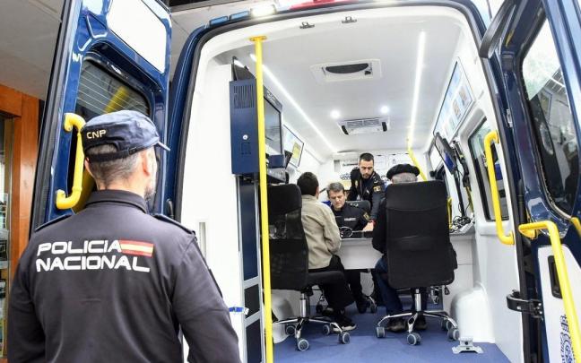 Funcionarios policiales atendiendo a unos ciudadanos en la furgoneta de expedición y renovación de documentos.