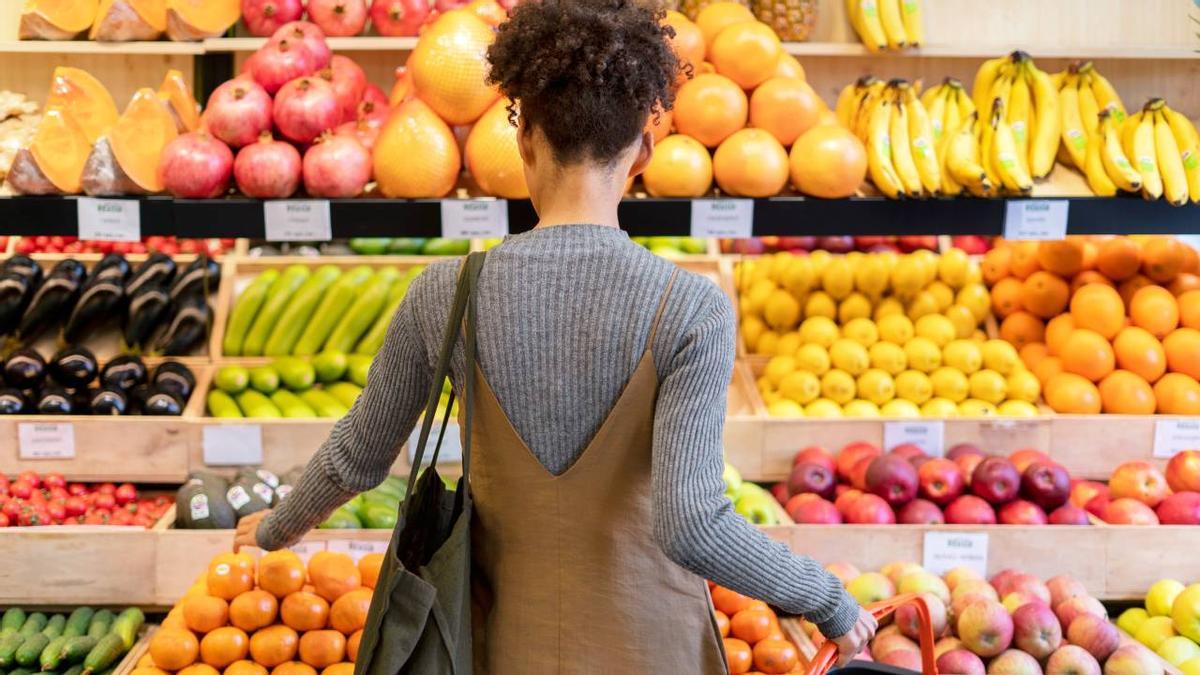 Una mujer compra fruta en un supermercado.