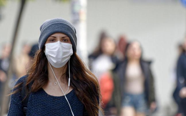 Una mujer pasea con mascarilla