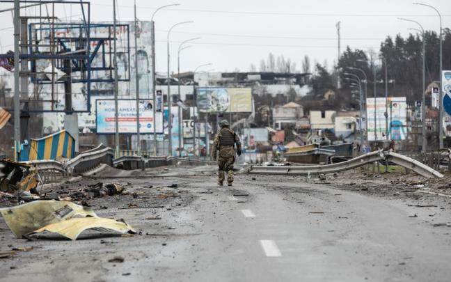 Un soldado camina por las calles devastadas de Bucha.