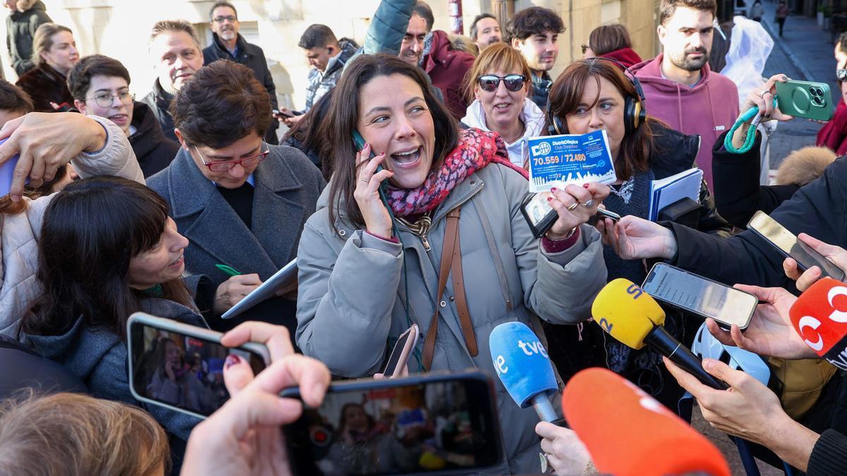 Una agraciada con una participación del Gordo de la Lotería de Navidad rodeada de medios a las puertas de la administración número 6 de Logroño