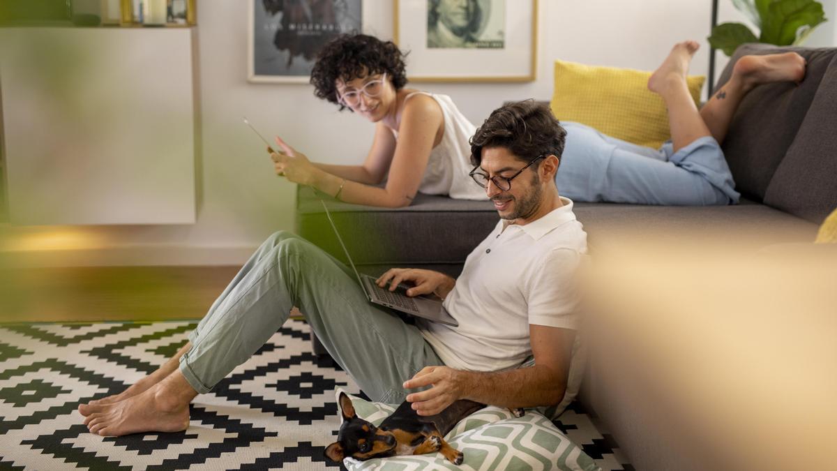 Dos jóvenes se conectan a Internet en casa.