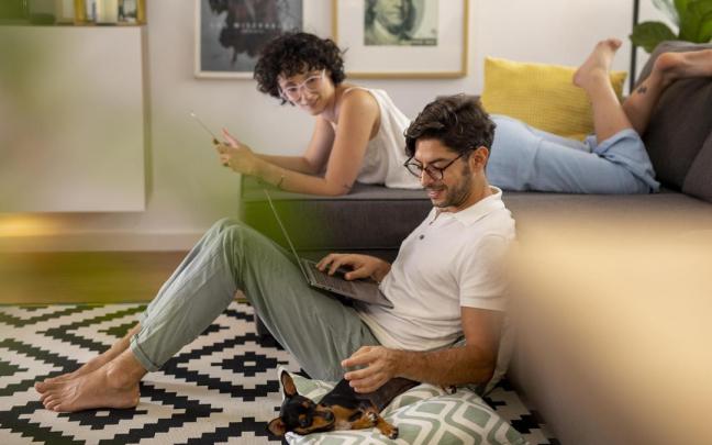 Dos jóvenes se conectan a Internet en casa.