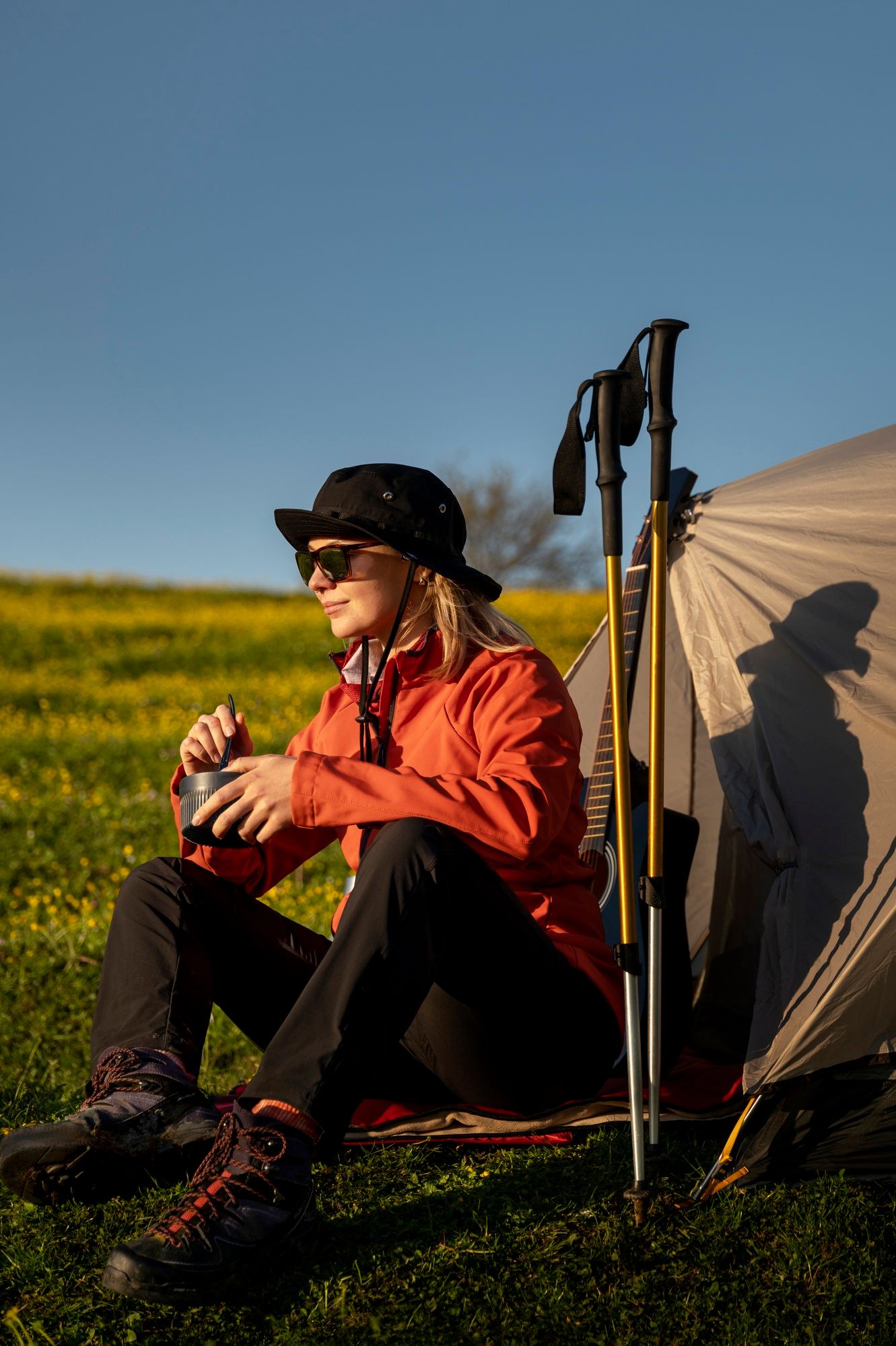 Una mujer descansa junto a sus bastones clavados en el suelo.