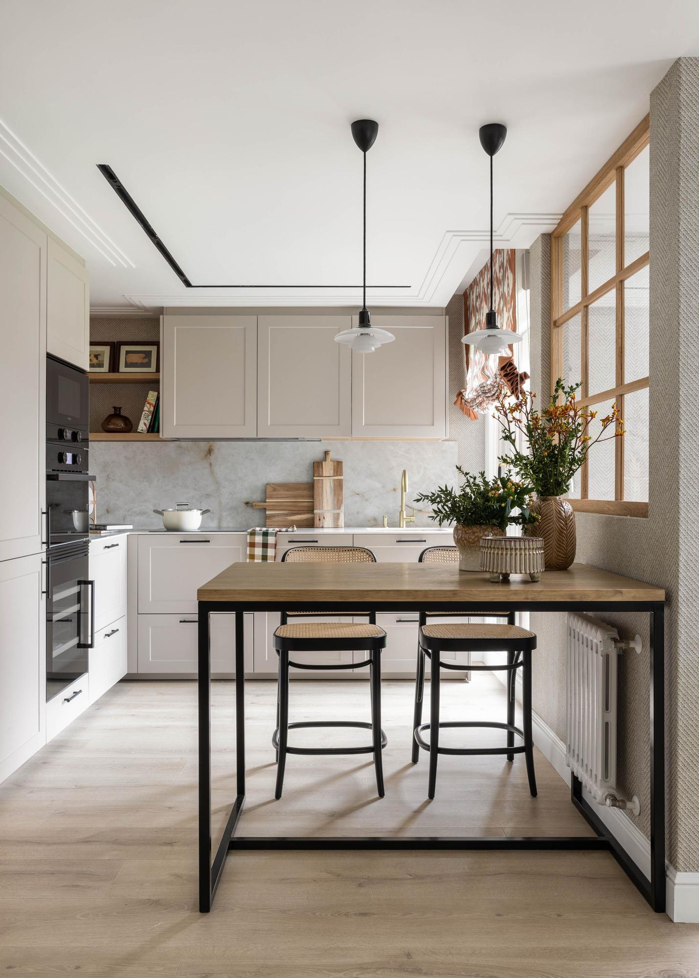 La cocina, con una barra alta, bajo el tabique de cristal.
