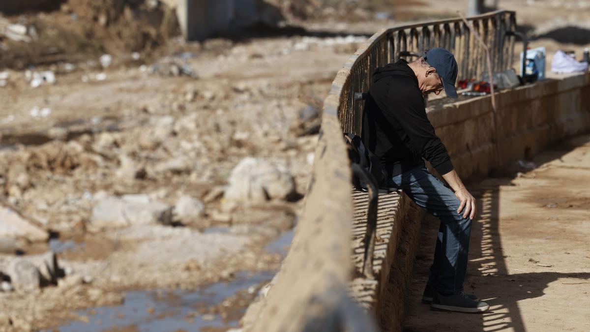 Un hombre junto al barranco del Poyo a su paso por la localidad de Paiporta.