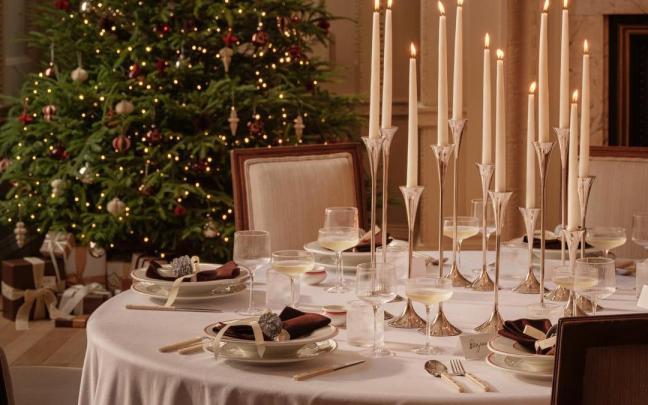 Elegante mesa de Navidad con velas a distintas alturas.