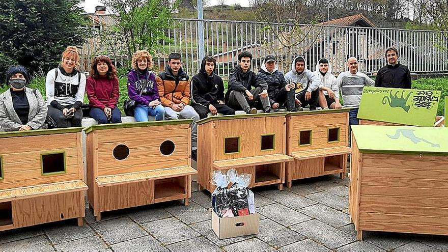 Miembros de Amukatu e HiruA junto a los comedores que les hizo el alumnado de carpintería del instituto Zaraobe de Amurrio.