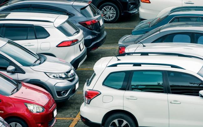 Coches de varios colores en un aparcamiento.