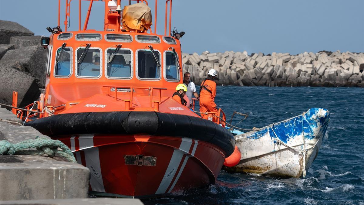 Trabajadores de la Guardia Civil, Cruz Roja y sanitarios durante la llegada de un cayuco, en el puerto de La Restinga.