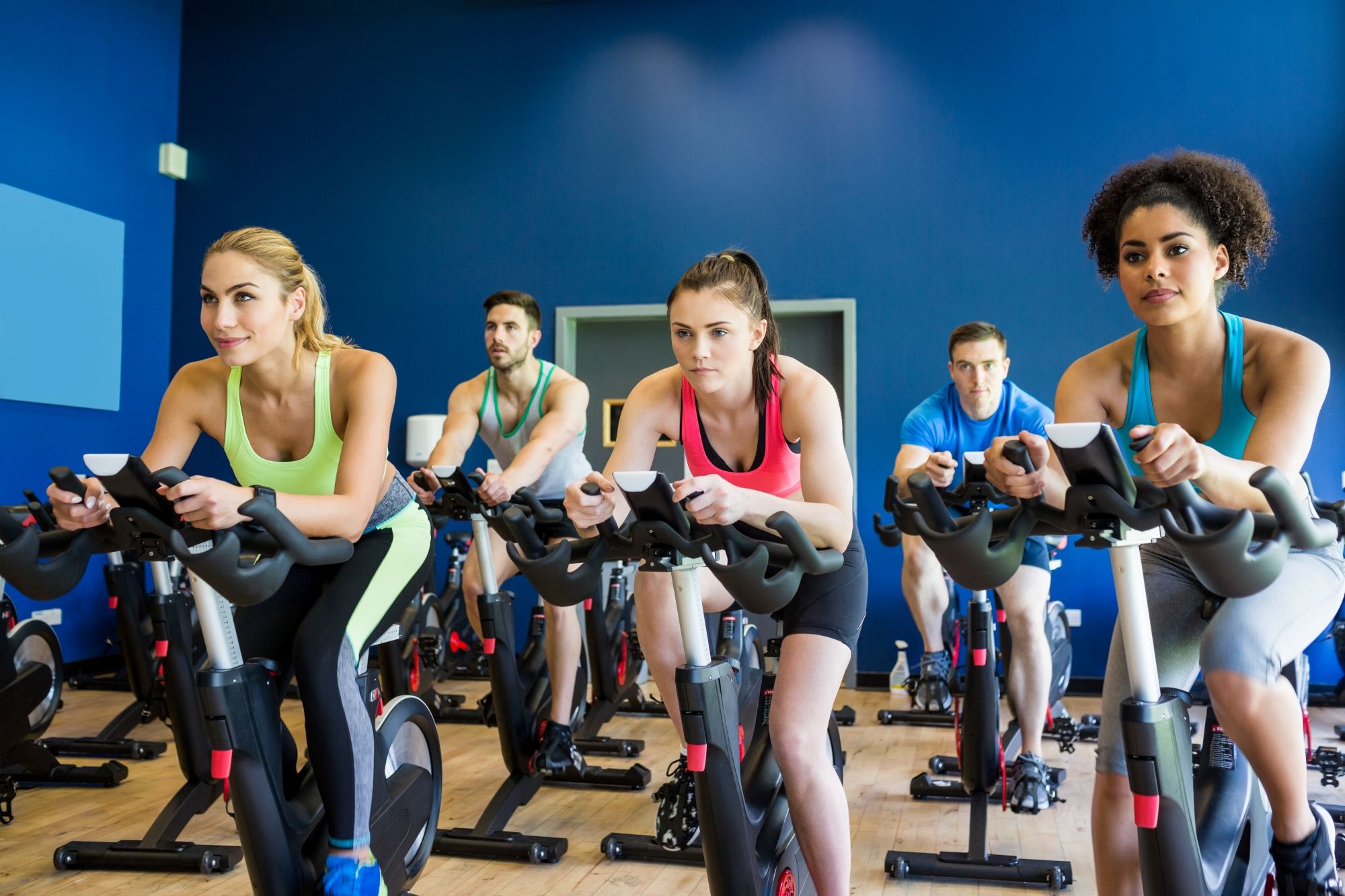 Un grupo de mujeres durante una clase de spinning en un gimnasio.