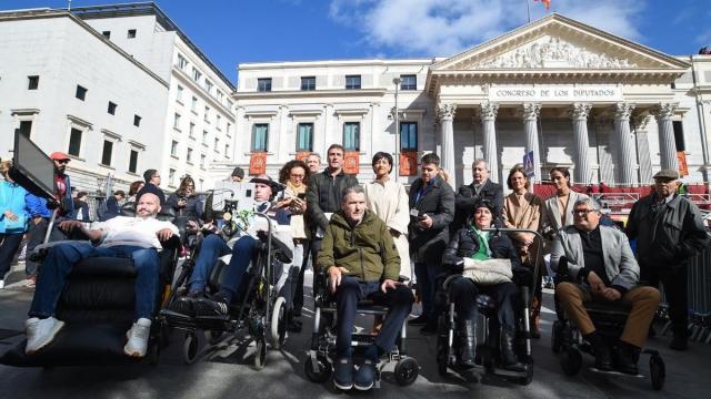 El exfutbolista y portavoz de ConELA, Juan Carlos Unzué (c), junto a otros enfermos de ELA ante el Congreso.