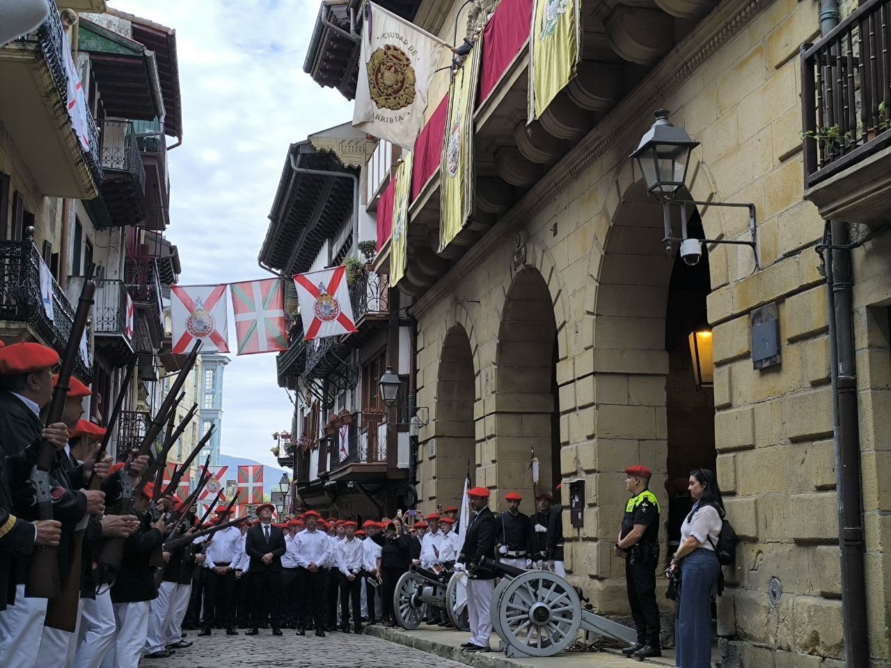 La bandera de Hondarribia en el Ayuntamiento, bajo la mirada de los soldados de Herria, miembros de Artillería y los Mandos del Alarde de Hondarribia
