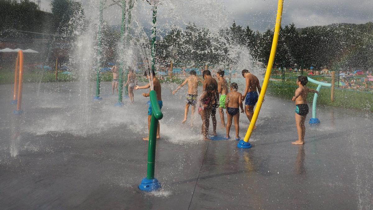 Un grupo de niños se divierte en el parque de chorros de agua de las piscinas de MIntxeta en Elgoibar.