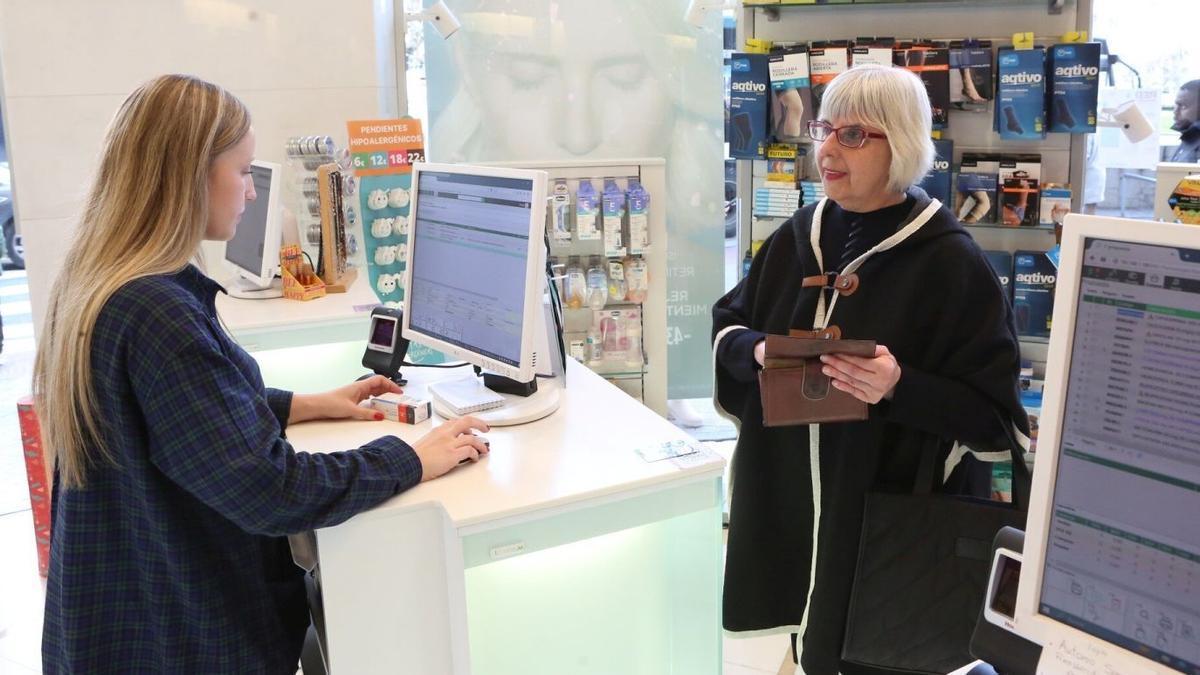 Una mujer adquiere un medicamento en una farmacia.