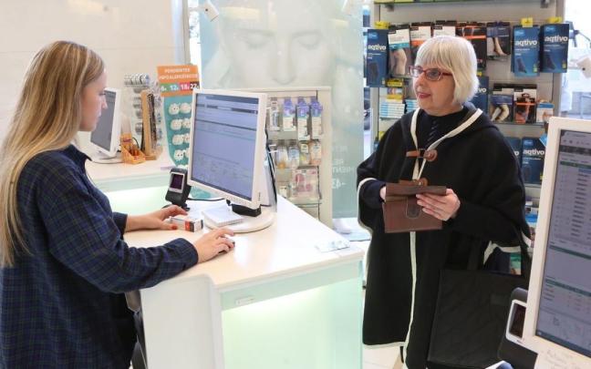 Una mujer adquiere un medicamento en una farmacia.