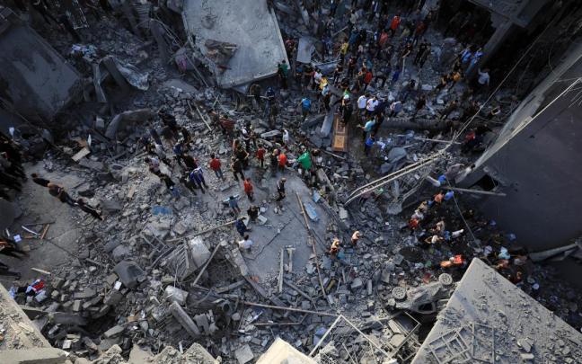 Gazatíes intentan encontrar víctimas entre los escombros de un bombardeo israelí.