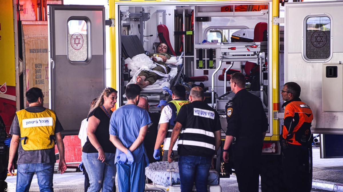 Una mujer herida es trasladada en una ambulancia.