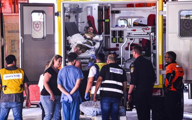 Una mujer herida es trasladada en una ambulancia.