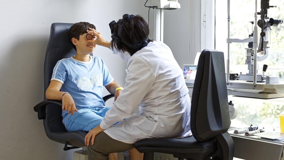 Una oftalmóloga realiza una revisión ocular a un niño en una clínica vizcaina.