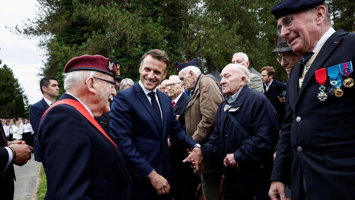 El presidente francés, Emmanuel Macron, conversa con varios veteranos de Normandía.