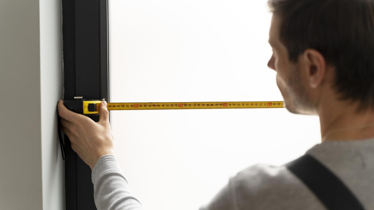 Un hombre repara una ventana