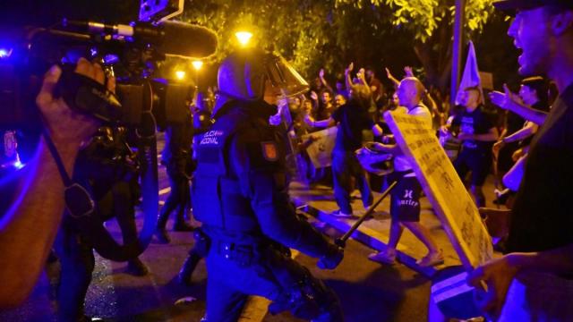 Miembros de los cuerpos antidisturbios de la Policia Nacional cargan contra los manifestantes que han participado este domingo en la manifestación.