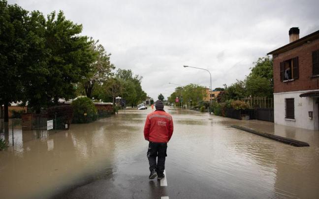 Un hombre pasea por una calle inundada en Castel Bolognese, Rávena.