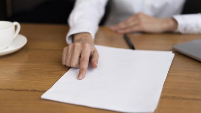 Una mujer extiende un contrato de trabajo sobre una mesa. / Freepik Una mujer extiende un contrato de trabajo sobre una mesa.