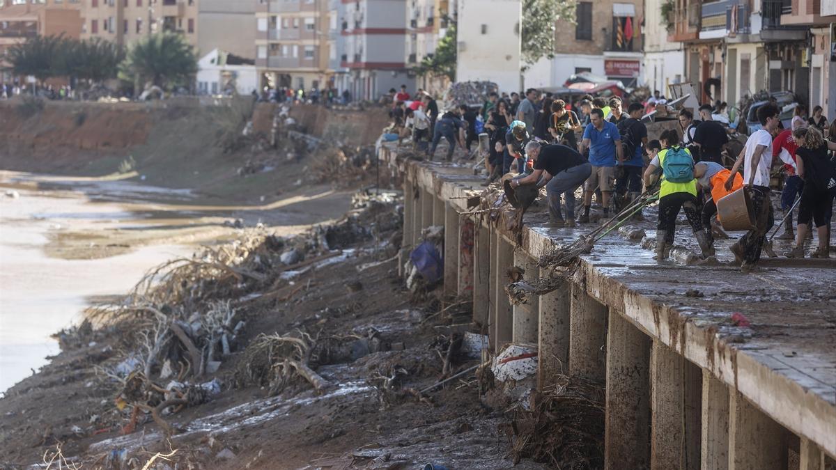 Varias personas limpiando los estragos causados por la DANA