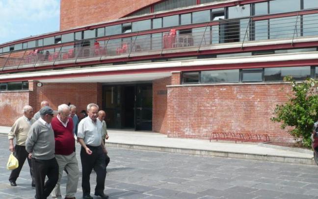 Un grupo de personas paseando por delante del polideportivo Allurralde.