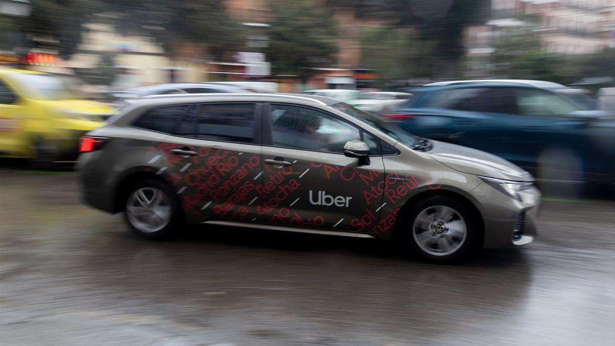 Un vehículo con licencia VTC circula por una calle de Madrid.
