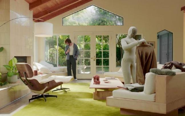 NEO cuelga un abrigo en una percha.