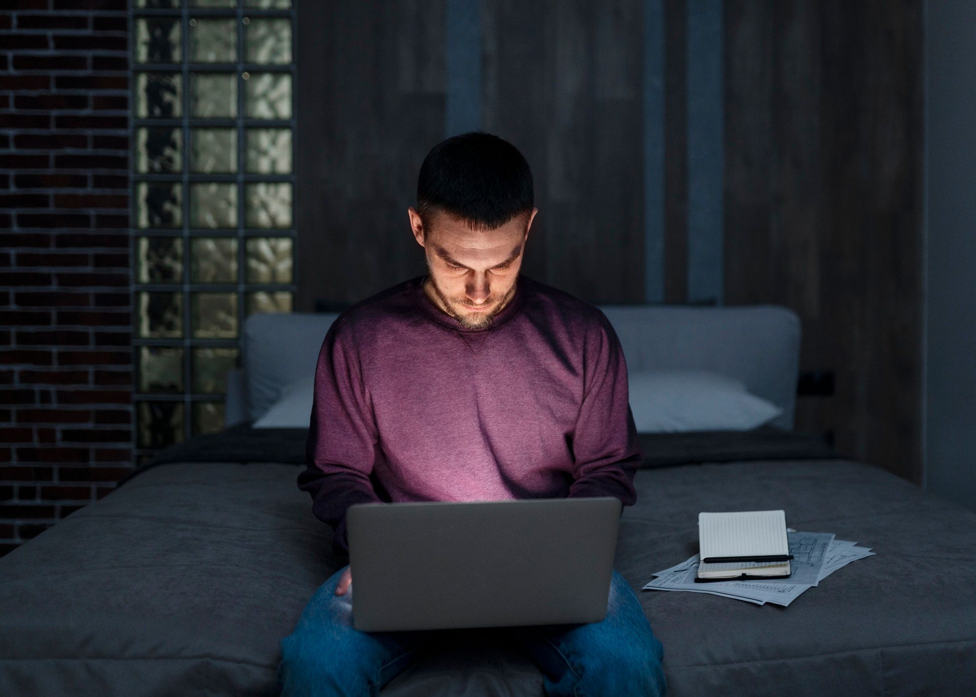 Un hombre chatea en la oscuridad de su habitación. Un hombre chatea en la oscuridad de su habitación.