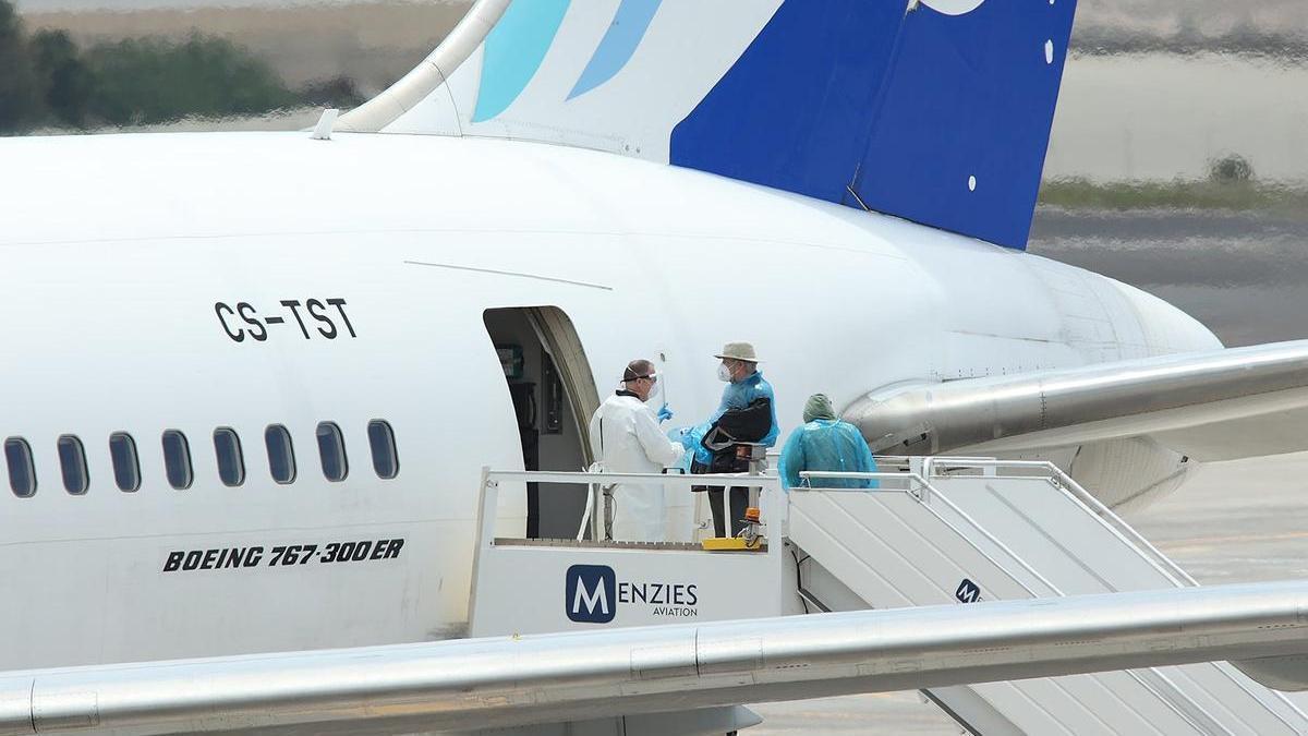 Viajeros de nacionalidad canadiense evacuados del crucero MV Hondius suben a un avión.