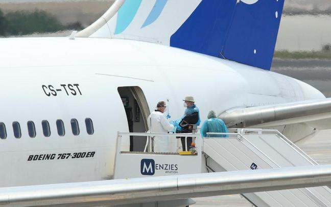 Viajeros de nacionalidad canadiense evacuados del crucero MV Hondius suben a un avión.