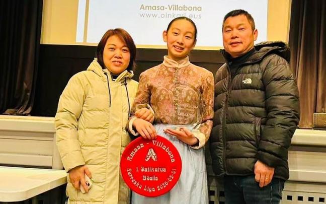 Yisha Wang y sus padres, en Villabona, con la txapela y el trofeo.
