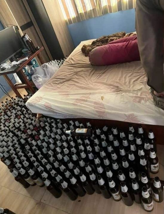 Un montón de botellines de cerveza junto a la cama.