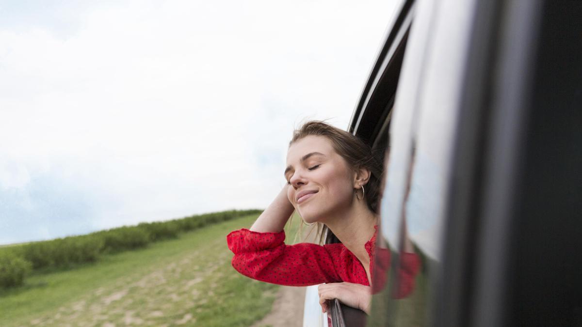 Mujer sacando el cuerpo por la ventanilla.