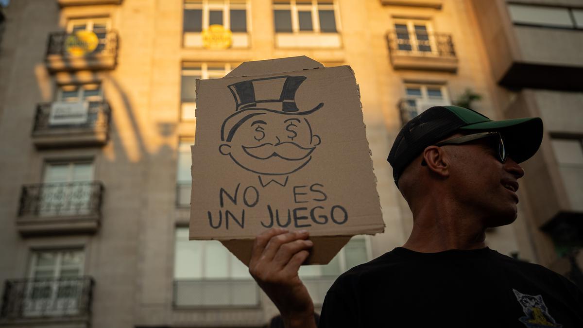 Una persona muestra un mensaje durante una manifestación para exigir una reducción del precio de los alquileres de la vivienda.