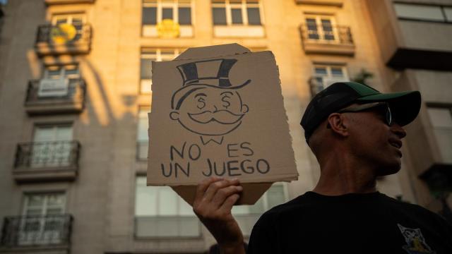 Una persona muestra un mensaje durante una manifestación para exigir una reducción del precio de los alquileres de la vivienda.