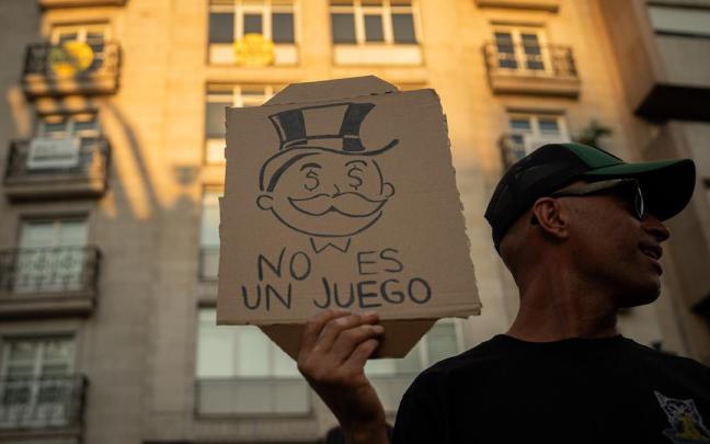 Una persona muestra un mensaje durante una manifestación para exigir una reducción del precio de los alquileres de la vivienda.