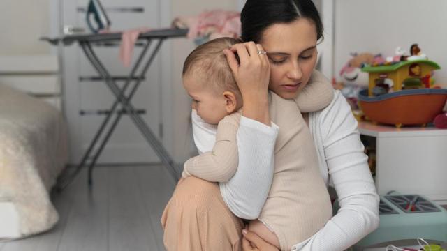 Madre abraza a su bebé con cariño.