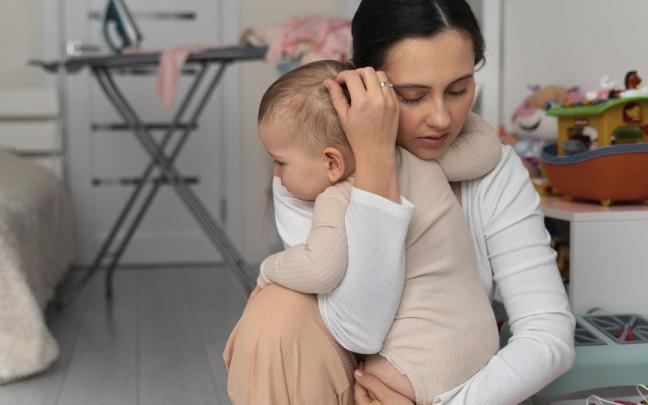 Madre abraza a su bebé con cariño.